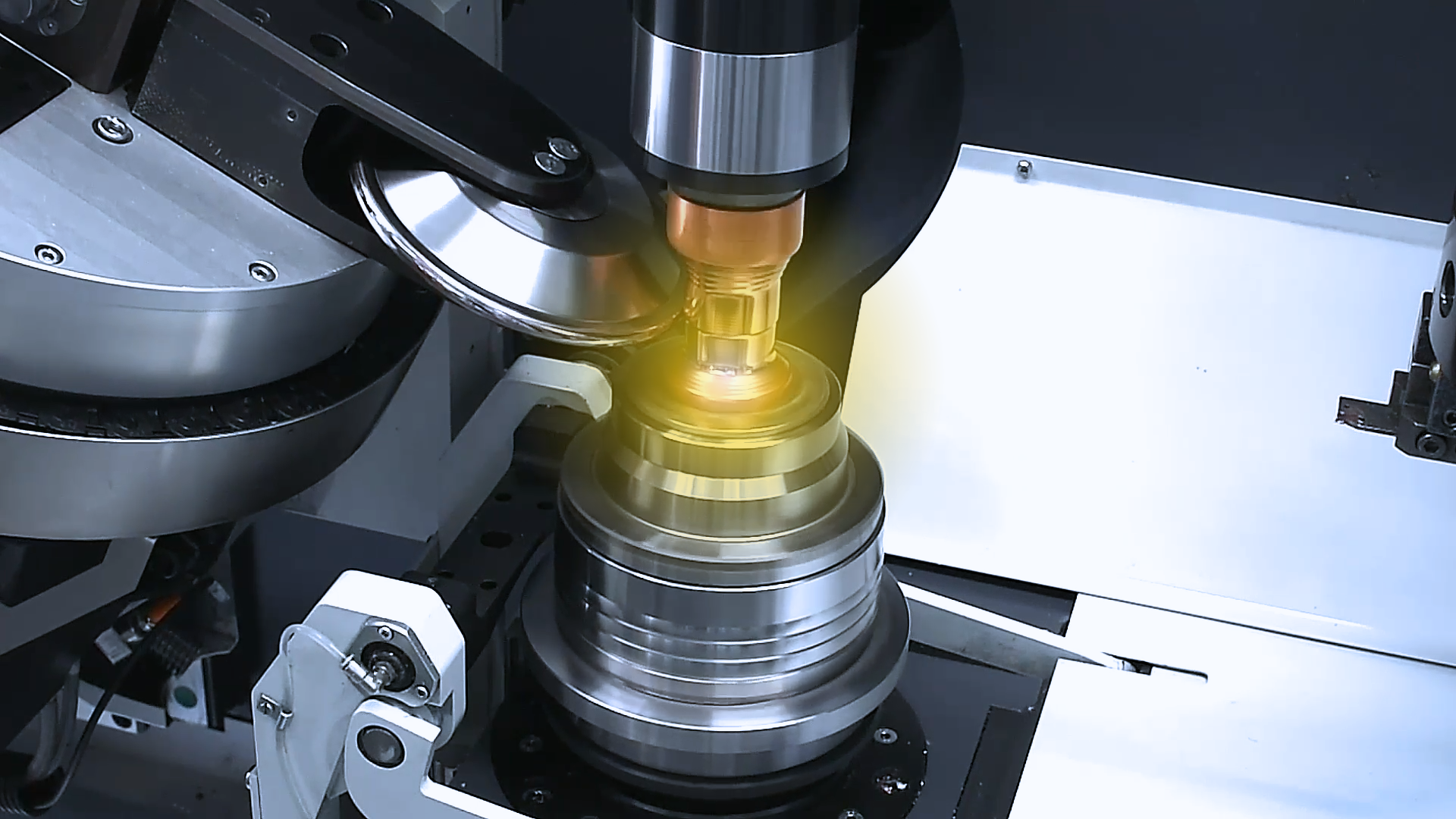 Eine Maschine fertigt ein Metallobjekt unter gelbem Licht an, das den Produktionsprozess beleuchtet.